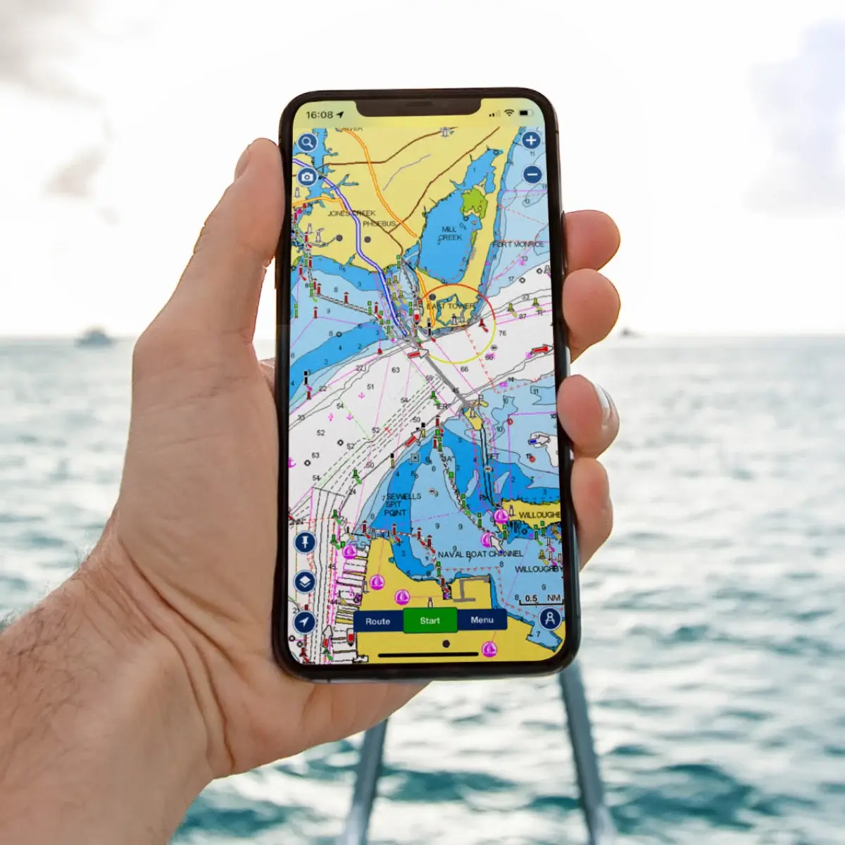 Смартфон с открытым приложением Navionics Boating HD на фоне моря — морская навигация на яхте