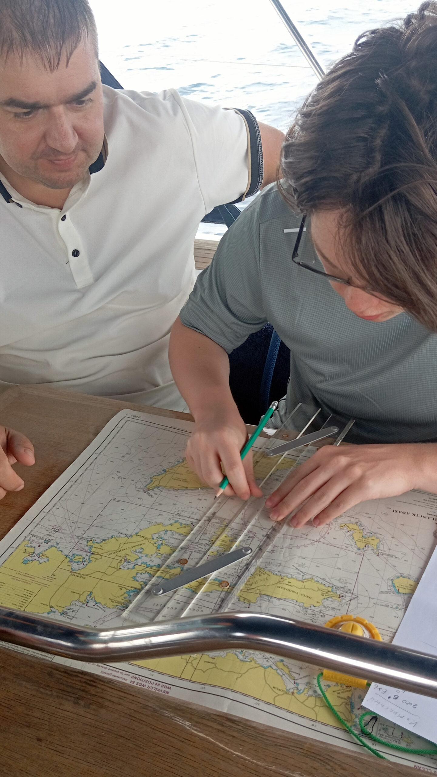 Курсанты яхт-школы Time to Sail работают с морскими картами во время учебного похода